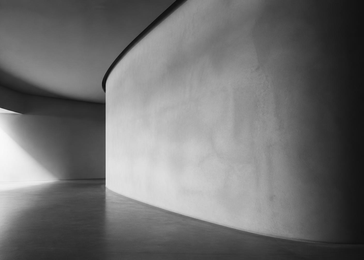 Curved plaster wall in a spacious minimal interior